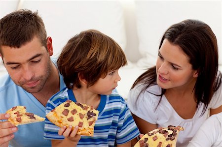 Happy parents and son eating pizza in living-room all together Stock Photo - Budget Royalty-Free & Subscription, Code: 400-04654735