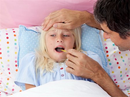 sick girl in bed with her father - Father checking his daughter's temperature with a thermometer in bed Stock Photo - Budget Royalty-Free & Subscription, Code: 400-04654764