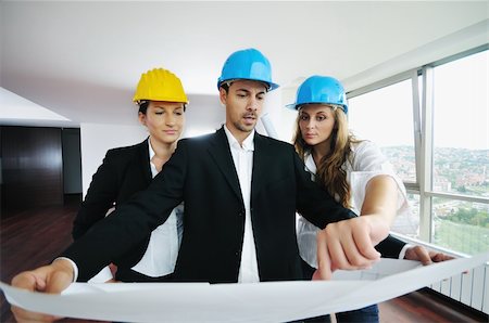 smiling industrial workers group photo - young arhitect group in big bright modern new apartment looking blueprints and building plans Stock Photo - Budget Royalty-Free & Subscription, Code: 400-04655266