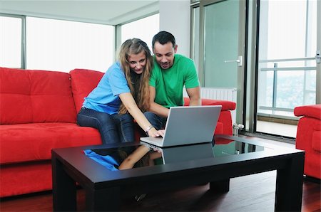 happy young couple have fun and relax at comfort bright apartment and work on laptop computerhappy young couple have fun and relax at comfort bright appartment and work on laptop computer Stock Photo - Budget Royalty-Free & Subscription, Code: 400-04655261