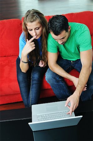 happy young couple have fun and relax at comfort bright apartment and work on laptop computerhappy young couple have fun and relax at comfort bright appartment and work on laptop computer Stock Photo - Budget Royalty-Free & Subscription, Code: 400-04655262