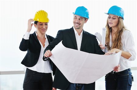 smiling industrial workers group photo - young arhitect group in big bright modern new apartment looking blueprints and building plans Stock Photo - Budget Royalty-Free & Subscription, Code: 400-04655276