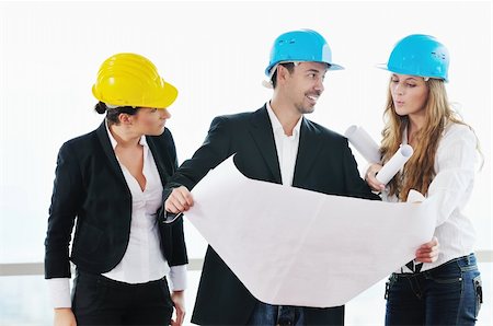 smiling industrial workers group photo - young arhitect group in big bright modern new apartment looking blueprints and building plans Stock Photo - Budget Royalty-Free & Subscription, Code: 400-04655287