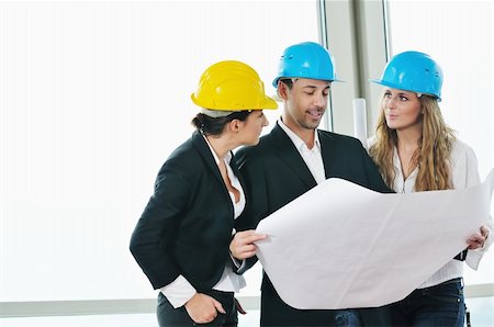 smiling industrial workers group photo - young arhitect group in big bright modern new apartment looking blueprints and building plans Stock Photo - Budget Royalty-Free & Subscription, Code: 400-04655307