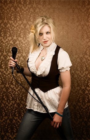 simsearch:400-04655366,k - Pretty young female blonde singer or comedian with microphone Stock Photo - Budget Royalty-Free & Subscription, Code: 400-04655365