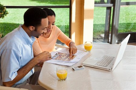 A successful African American man and woman couple in their thirties using a laptop computer to look for property on the internet Stock Photo - Budget Royalty-Free & Subscription, Code: 400-04655439