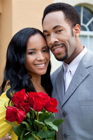 simsearch:400-04655736,k - A romantic and happy African American man and woman couple in their thirties smiling together with a bunch of roses. Stockbilder - Microstock & Abonnement, Bildnummer: 400-04655736
