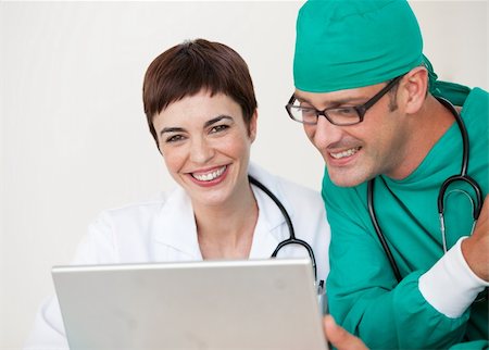 doctor speaking to young patient - Young Doctor and surgeon looking at a laptop Stock Photo - Budget Royalty-Free & Subscription, Code: 400-04657505