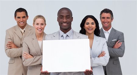 simsearch:400-05155599,k - Smiling Afro-American businessman holding a white card with his team Stock Photo - Budget Royalty-Free & Subscription, Code: 400-04657501