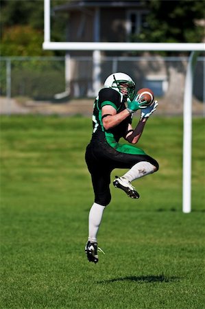 simsearch:400-04044185,k - A football player leaping off the ground, to catch the ball near the goal posts. Stock Photo - Budget Royalty-Free & Subscription, Code: 400-04658760