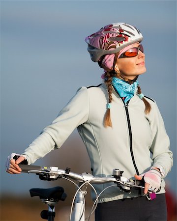 simsearch:400-04336549,k - Active young woman with her bicycle. Smiling and looking at the sun Fotografie stock - Microstock e Abbonamento, Codice: 400-04658790