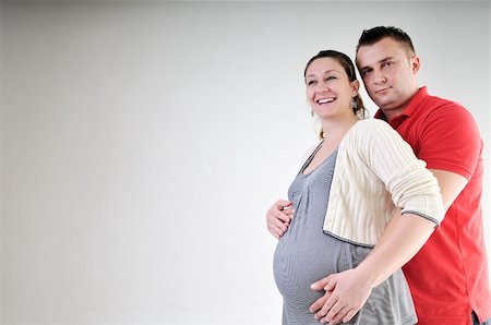 pregnant women kissing - young family couple together in studio isolated on white. happy and waiting for baby Stock Photo - Budget Royalty-Free & Subscription, Code: 400-04659386