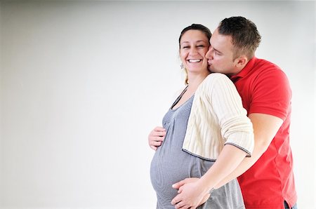 pregnant women kissing - young family couple together in studio isolated on white. happy and waiting for baby Stock Photo - Budget Royalty-Free & Subscription, Code: 400-04659387