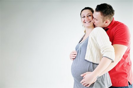 pregnant women kissing - young family couple together in studio isolated on white. happy and waiting for baby Stock Photo - Budget Royalty-Free & Subscription, Code: 400-04659388
