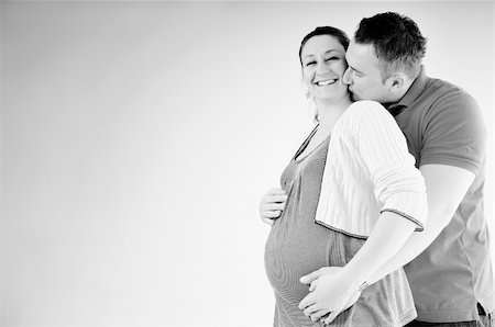 pregnant women kissing - young family couple together in studio isolated on white. happy and waiting for baby Stock Photo - Budget Royalty-Free & Subscription, Code: 400-04659389