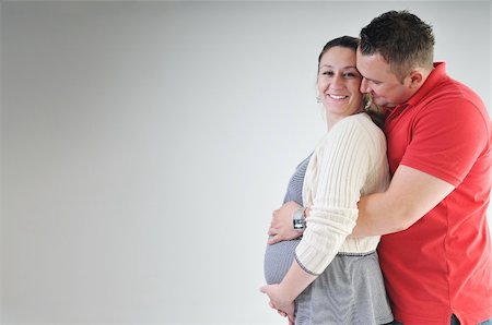 pregnant women kissing - young family couple together in studio isolated on white. happy and waiting for baby Stock Photo - Budget Royalty-Free & Subscription, Code: 400-04659394
