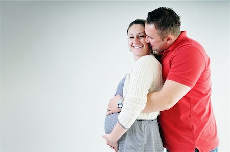 pregnant women kissing - young family couple together in studio isolated on white. happy and waiting for baby Stock Photo - Budget Royalty-Free & Subscription, Code: 400-04659395