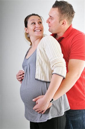 pregnant women kissing - young family couple together in studio isolated on white. happy and waiting for baby Stock Photo - Budget Royalty-Free & Subscription, Code: 400-04659390