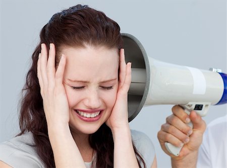 simsearch:400-09223567,k - Angry businesswoman listening to a megaphone in the office Stock Photo - Budget Royalty-Free & Subscription, Code: 400-04659656