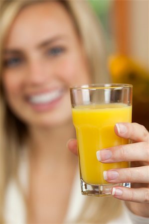 simsearch:632-07674617,k - A young woman is holding a glass of orange juice and smiling at the camera.  Vertically framed shot. Stockbilder - Microstock & Abonnement, Bildnummer: 400-04659968