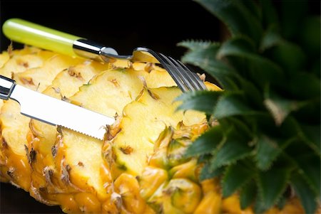 simsearch:400-04650758,k - ripe vibrant pineapple sliced on a black plate with knife and fork Stock Photo - Budget Royalty-Free & Subscription, Code: 400-04650759