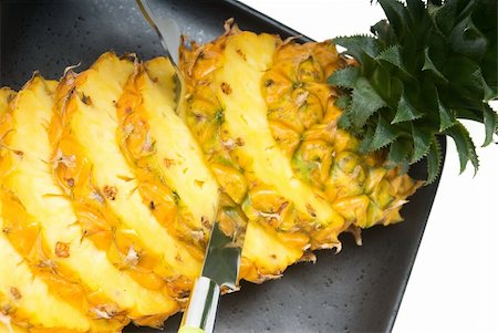 simsearch:400-04650758,k - ripe vibrant pineapple sliced on a black plate with knife and fork Stock Photo - Budget Royalty-Free & Subscription, Code: 400-04650760