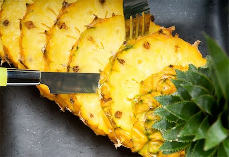 simsearch:400-04650758,k - ripe vibrant pineapple sliced on a black plate with knife and fork Stock Photo - Budget Royalty-Free & Subscription, Code: 400-04650761
