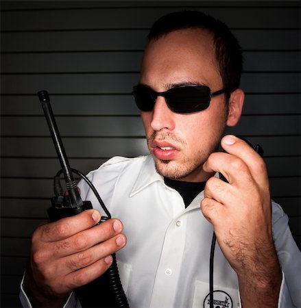 security guard in uniform with walky talky - Security patrol officer talking into a modile radio Stock Photo - Budget Royalty-Free & Subscription, Code: 400-04651971