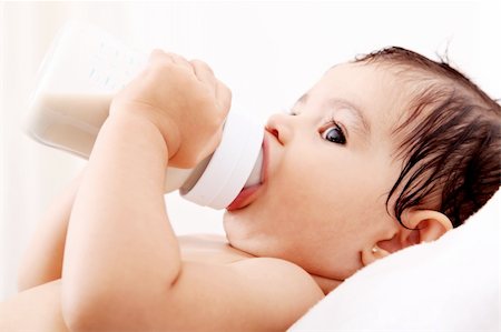 family eating light - Baby drinking milk of her bottle. White background Stock Photo - Budget Royalty-Free & Subscription, Code: 400-04652073