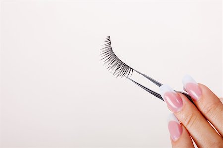 Woman hand holding false eyelashes in pincers Stock Photo - Budget Royalty-Free & Subscription, Code: 400-04652271