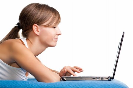 Happy young girl chatting using her laptop. Isolated white background Stock Photo - Budget Royalty-Free & Subscription, Code: 400-04652956