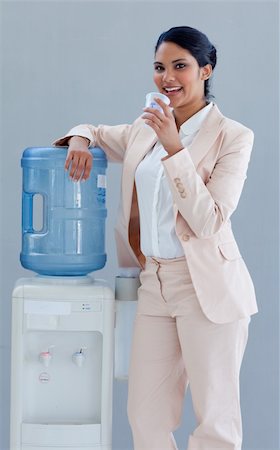 Businesswoman drinking from a water cooler in office Stock Photo - Budget Royalty-Free & Subscription, Code: 400-04653099