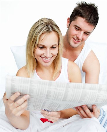 simsearch:400-04878558,k - Young couple reading newspaper together in bed Stock Photo - Budget Royalty-Free & Subscription, Code: 400-04653335