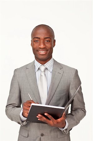 Attractive standing Afro-American businessman writing notes and smiling at the camera Stock Photo - Budget Royalty-Free & Subscription, Code: 400-04653374