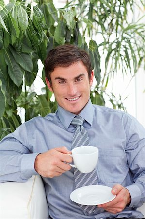 simsearch:400-05714996,k - Happy businessman drinking a cup of coffee on sofa Foto de stock - Super Valor sin royalties y Suscripción, Código: 400-04653548