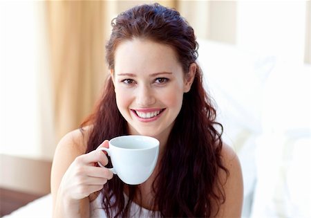 Smiling woman drinking a cup of coffee in bedroom in the morning Stock Photo - Budget Royalty-Free & Subscription, Code: 400-04653569