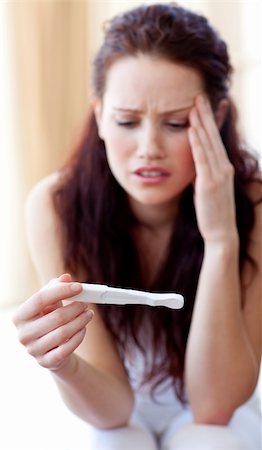 pregnant surprise - Woman looking at a pregnancy test in bedroom Stock Photo - Budget Royalty-Free & Subscription, Code: 400-04653574
