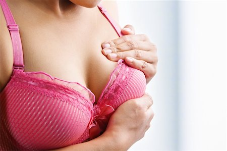 simsearch:400-04150821,k - Woman doing self breast examination using pink bra Stock Photo - Budget Royalty-Free & Subscription, Code: 400-04653691