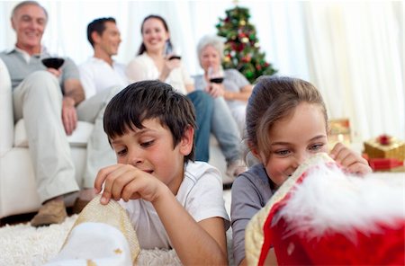 Children looking for presents in Christmas boots and family on sofa Stock Photo - Budget Royalty-Free & Subscription, Code: 400-04653975