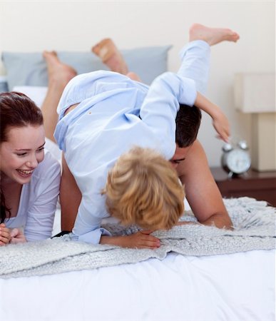 simsearch:400-04192370,k - Little son playing with his parents in bed Fotografie stock - Microstock e Abbonamento, Codice: 400-04653988