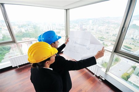 smiling industrial workers group photo - young arhitect group in big bright modern new apartment looking blueprints and building plans Stock Photo - Budget Royalty-Free & Subscription, Code: 400-04664017