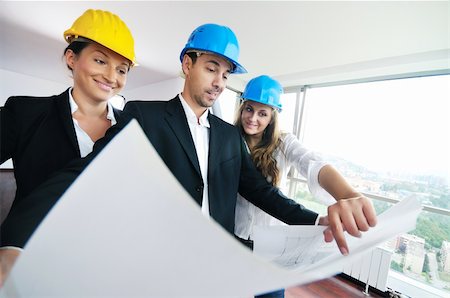 smiling industrial workers group photo - young arhitect group in big bright modern new apartment looking blueprints and building plans Stock Photo - Budget Royalty-Free & Subscription, Code: 400-04664107
