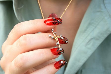 Nail-art fingers holding golden cross with necklace. Stock Photo - Budget Royalty-Free & Subscription, Code: 400-04666033