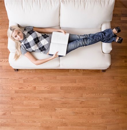 Full length overhead view of woman reclining on white couch with a book, as she looks up at the camera. Square format. Stock Photo - Budget Royalty-Free & Subscription, Code: 400-04666427