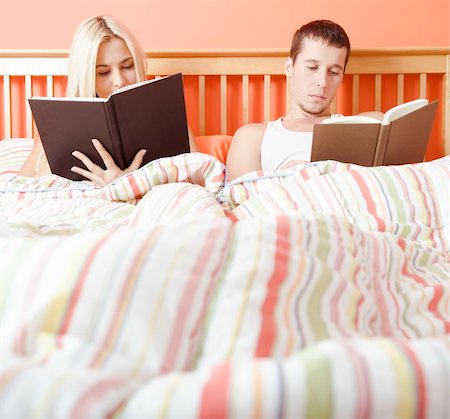 Man and woman reading side-by-side in bed. Square format. Fotografie stock - Microstock e Abbonamento, Codice: 400-04666438