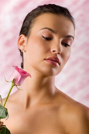 simsearch:400-06096871,k - close up portrait of a pretty brunette with a pink rose looking down Stock Photo - Budget Royalty-Free & Subscription, Code: 400-04667003