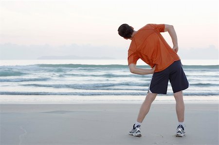 simsearch:400-04790531,k - Runner doing stretching exercises on a beach early in the morning Foto de stock - Royalty-Free Super Valor e Assinatura, Número: 400-04668875