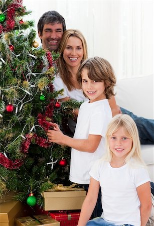 simsearch:400-04147489,k - Portrait of a happy family decorating a Christmas tree at home Photographie de stock - Aubaine LD & Abonnement, Code: 400-04660016