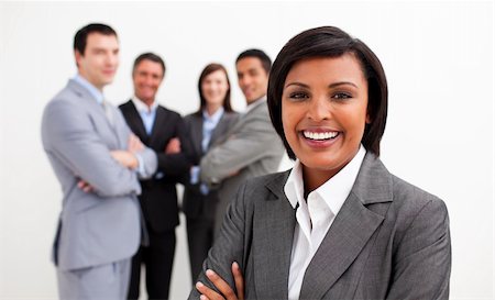 simsearch:400-06567931,k - Ethnic businesswoman smiling at the camera with her colleagues in the background Stock Photo - Budget Royalty-Free & Subscription, Code: 400-04660295