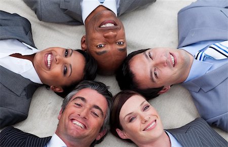 Multi-ethnic business team lying on the floor with heads together. Business concept. Foto de stock - Super Valor sin royalties y Suscripción, Código: 400-04660308